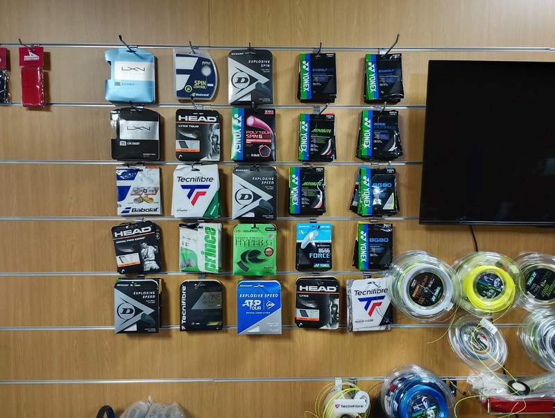 The wall of string packets and reels at The Racket Shop